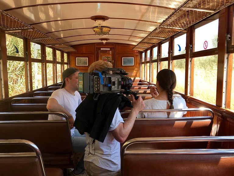cameraman films woman on soller train for a travel film shot in Palma de Mallorca