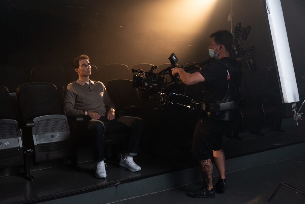 rafa nadal sits in the cinema as cameraman films him with steadicam for a commercial production filming in mallorca