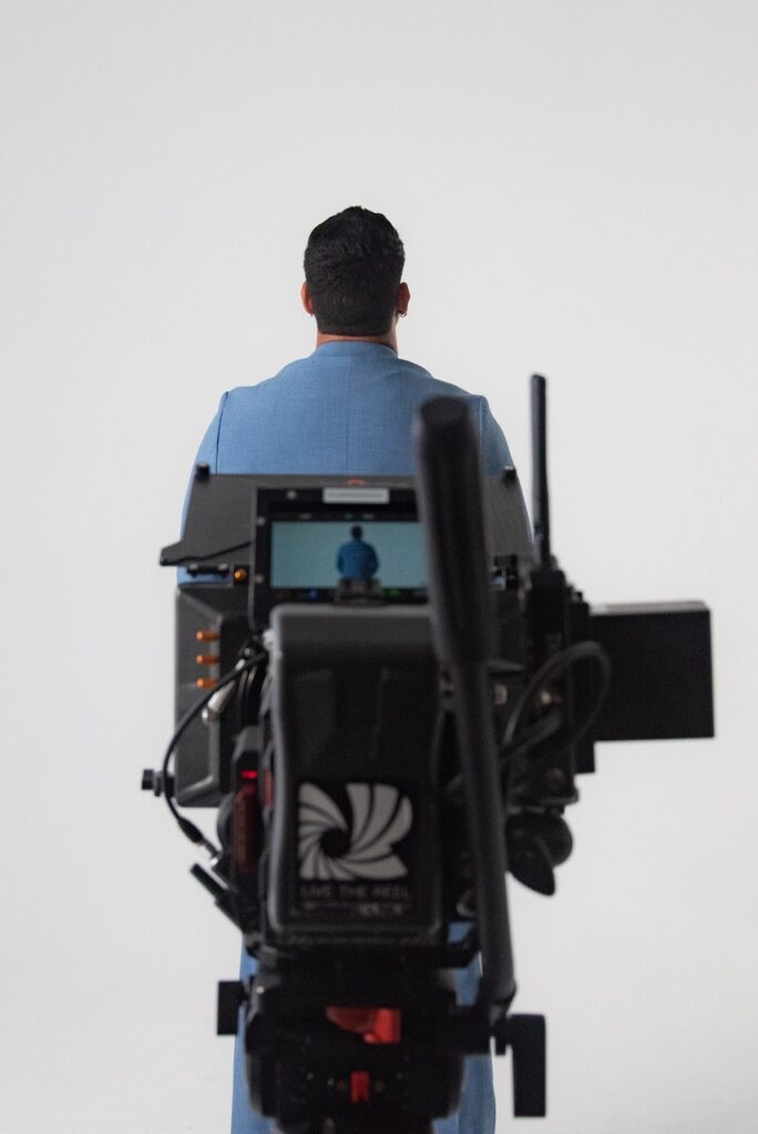 camera films man in blue suit in a mallorca studio shoot